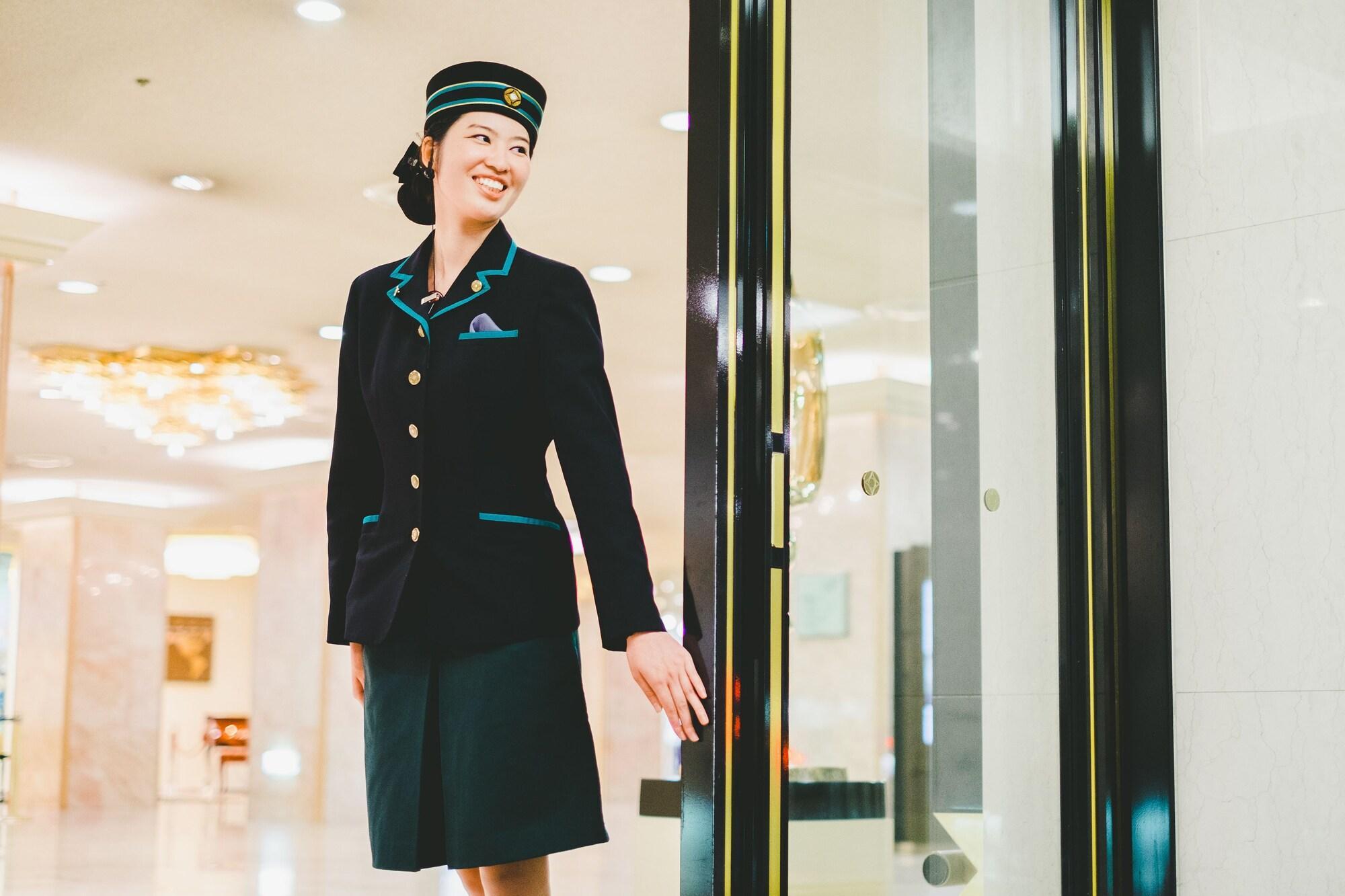 Hotel New Otani Hakata Φουκουόκα Εξωτερικό φωτογραφία A female doorman at the entrance of a hotel